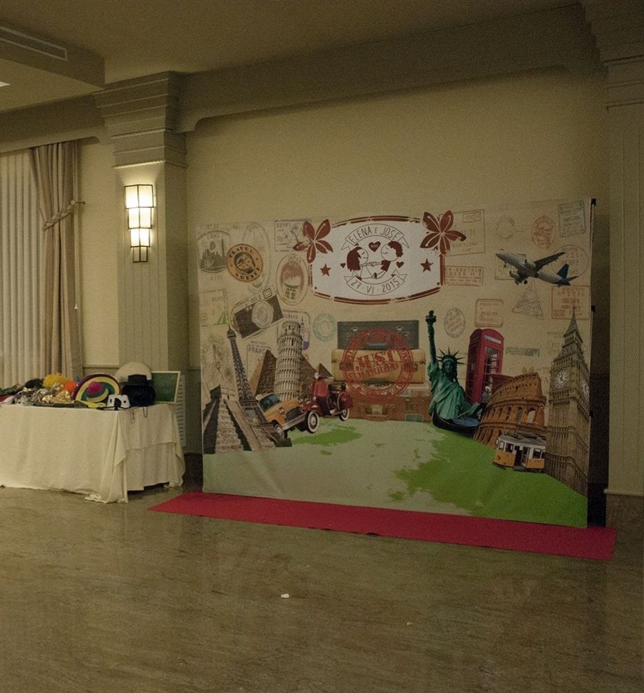 Fotocall personalizado con fondo temático de viajes y mesa de complementos en un evento